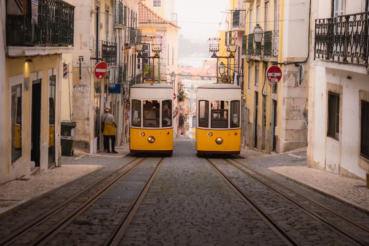 A yellow tram 28 climbing a cobbled street in Lisbon, Portugal
