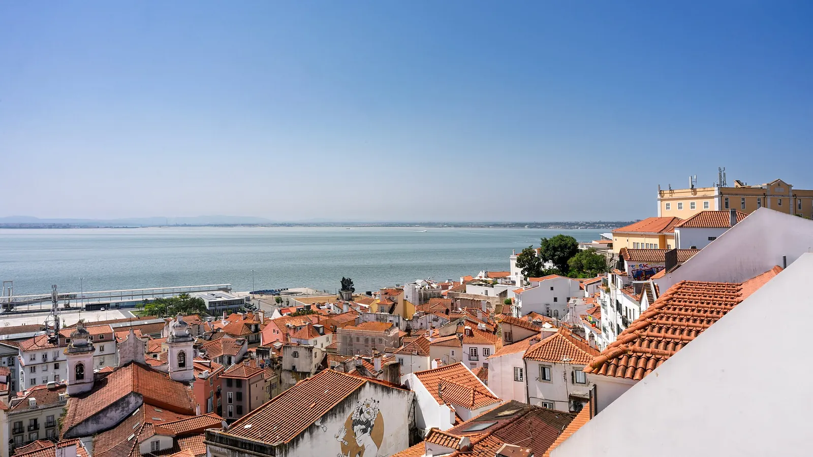View over the terracotta rooftops of Alfama towards the Tagus river in Lisbon, Portugal