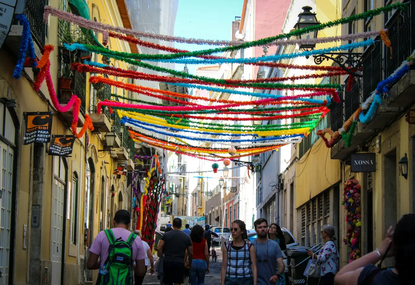 A narrow street strung with colourful paper garlands during the summer street festivals, Portugal