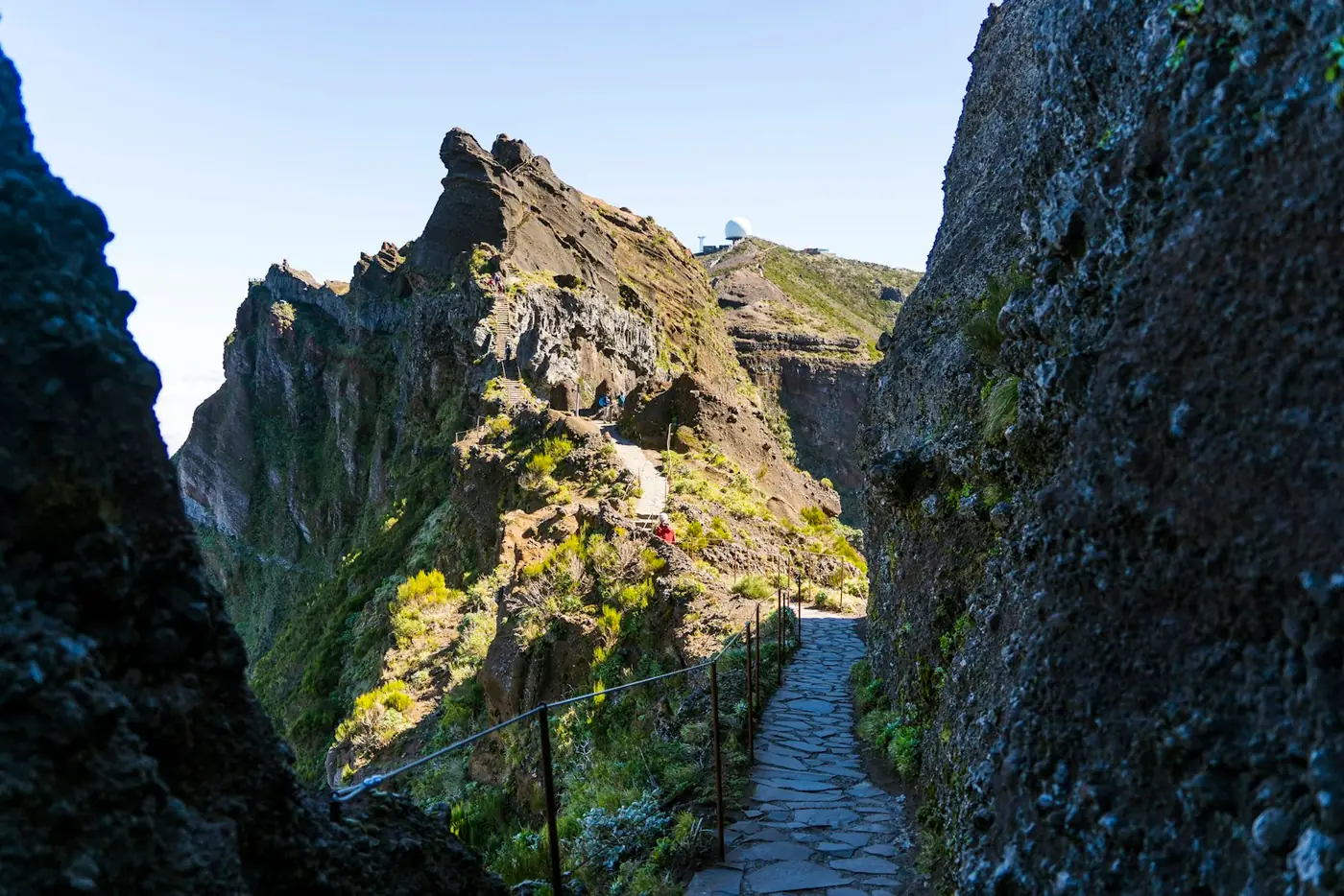 A paved stepped path cut between rock walls on the Pico do Areeiro trail in Madeira, Portugal