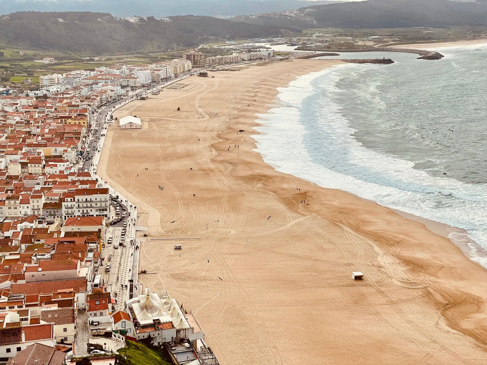 The wide crescent town beach of Nazare seen from the clifftop viewpoint, Portugal