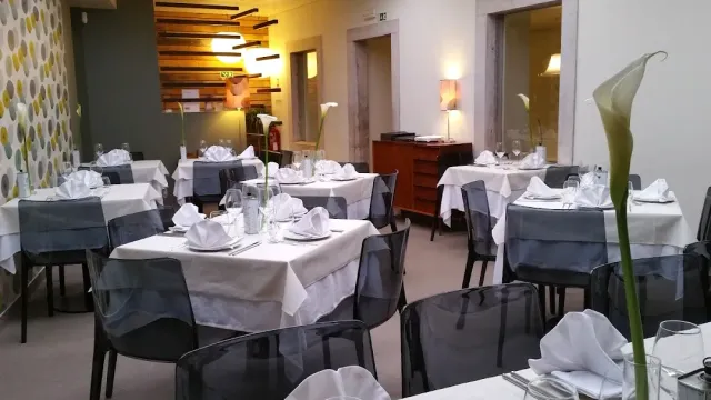 Tables set with white and grey cloths, transparent chairs and calla flowers