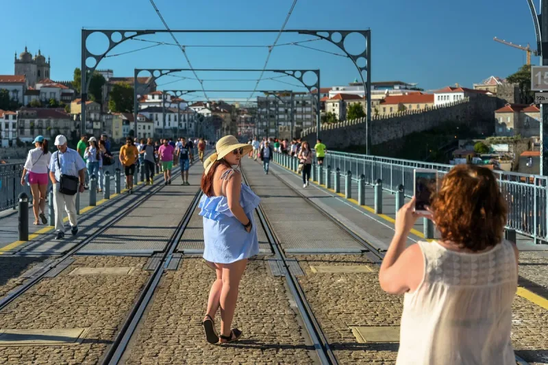 Pedestrians on the upper deck of the Dom Luis I bridge in Porto, beside the tram rails