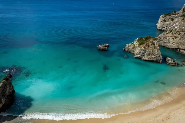 A small bay of turquoise water between pale cliffs