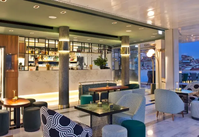 A lounge with columns, geometrically patterned armchairs and a bar counter facing the city view