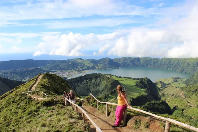 A ridge path with a wooden rail above green crater lakes