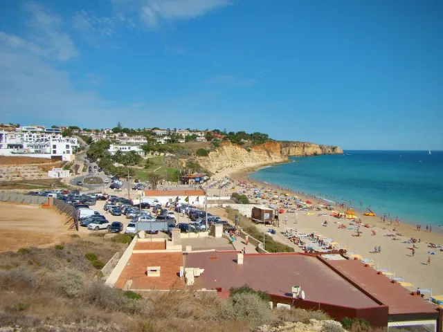 A long beach below cliffs with white houses at one end