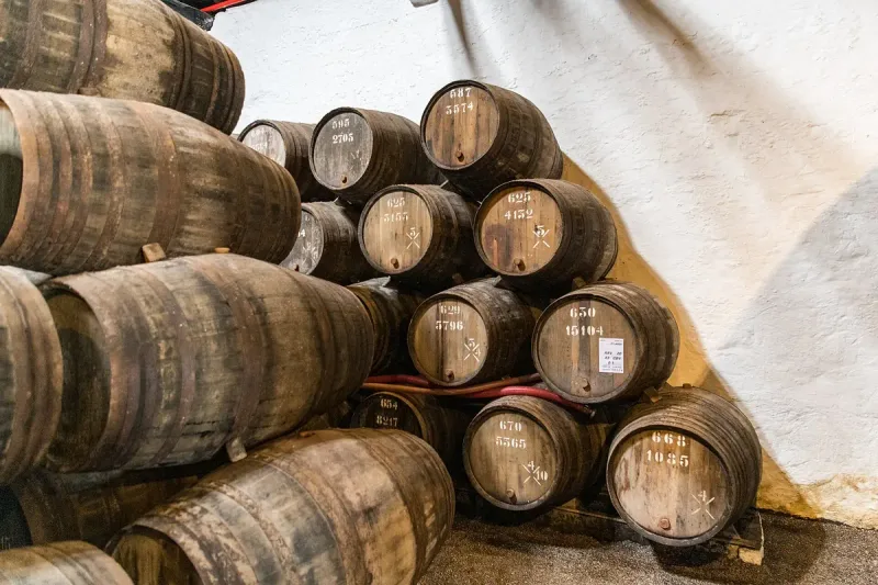 Stacks of dark aged wooden casks inside a lodge hall