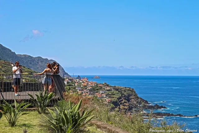 A viewing deck above a winding coastline and deep blue water