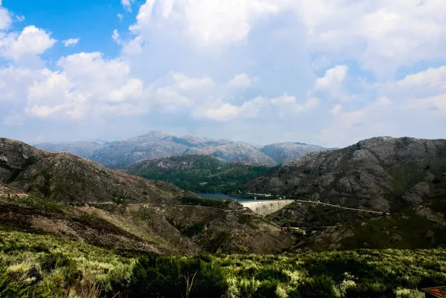 Green mountain ridges with a dam wall and reservoir deep in the valley