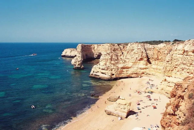 A sandy cove between pale limestone cliffs and turquoise water