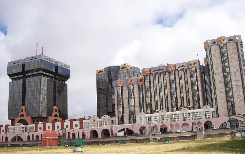 Postmodern grey and pink towers with stepped turrets above a row of arches