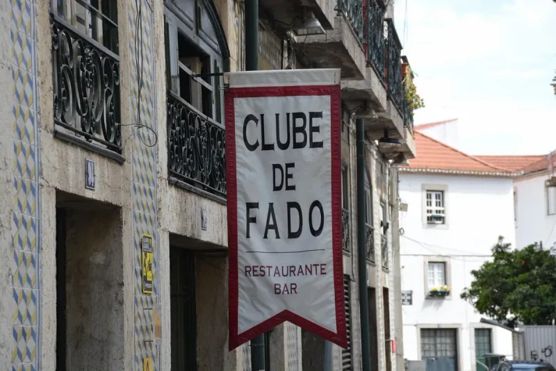The sign of Clube de Fado in an Alfama lane, on the tiled wall