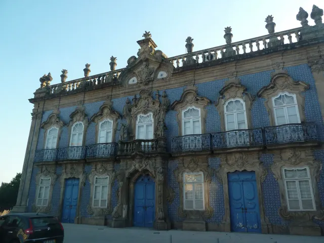 A palace front clad in blue tiles with white carved window frames