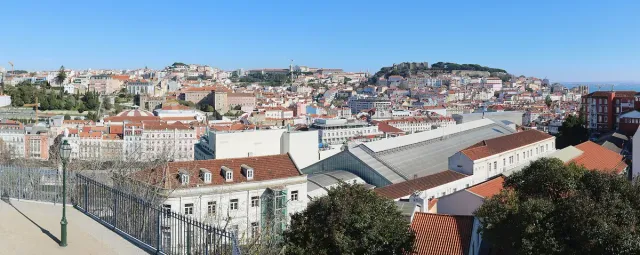 A railed terrace above a sea of orange tiled roofs and a hilltop fortress