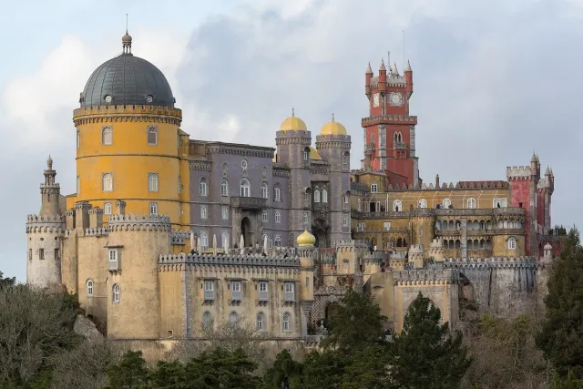 A palace in yellow, red and grey with a dome, turrets and carved terraces