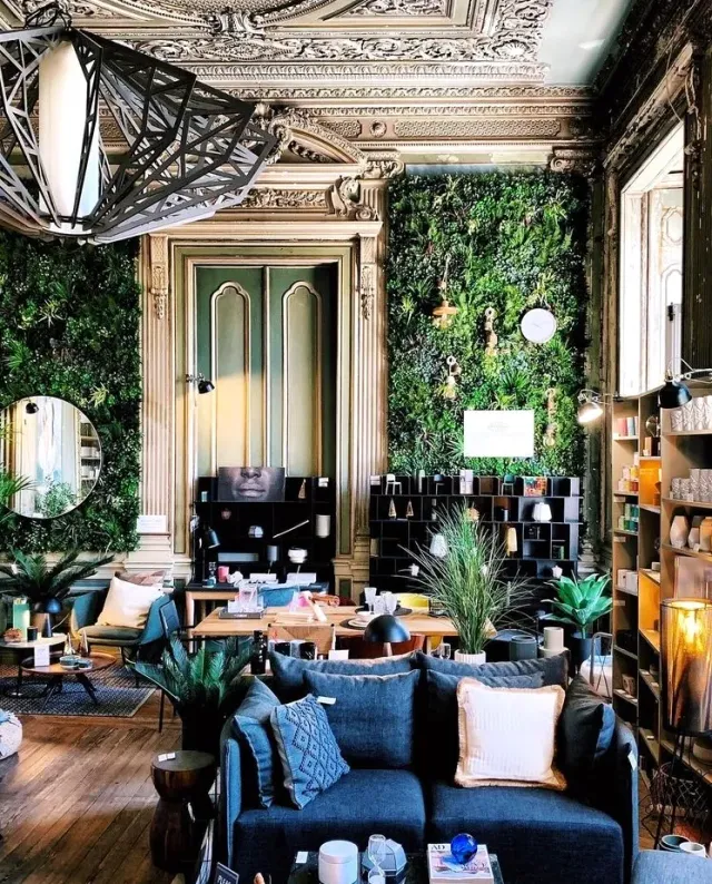 A palatial space with an ornate plaster ceiling, green plant walls and design items
