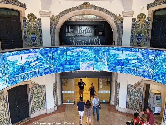 An arched entrance clad in blue tiles with visitors going in