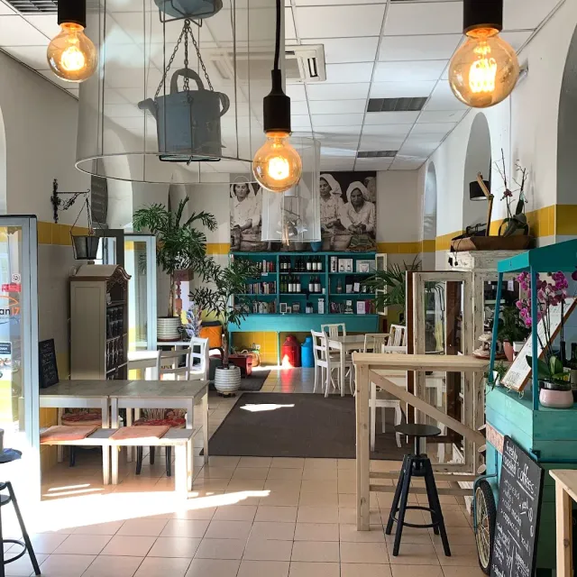 A space with globe bulbs, turquoise shelves, plants and a large black and white photograph