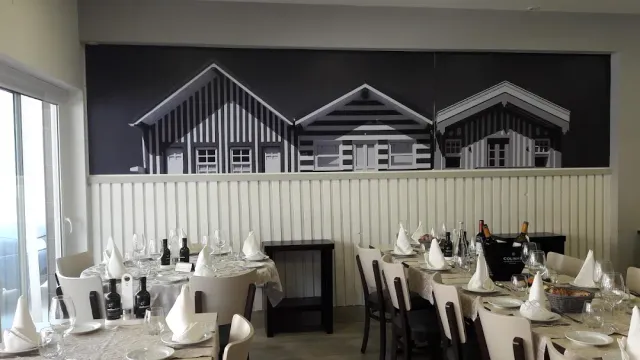 A black and white wall painting of striped houses above long set tables