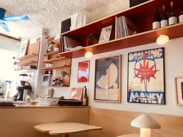 Rust-toned shelves with records and bottles, framed posters and a coffee machine on the counter