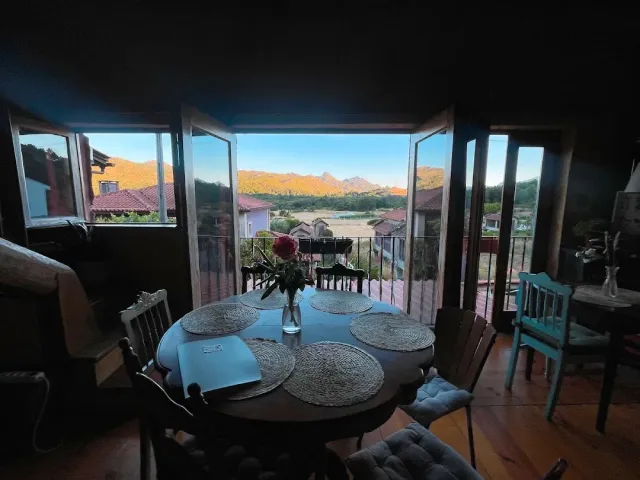 A round set table facing corner windows with a golden lit mountain view