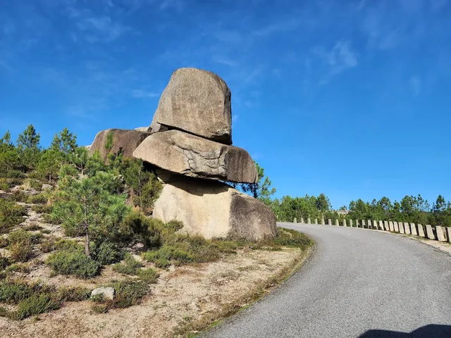Huge granite boulders stacked on each other beside a winding mountain road
