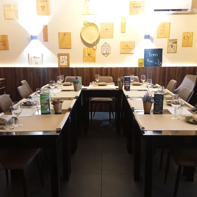 Tables set in a horseshoe facing a wall of wooden wine crate panels