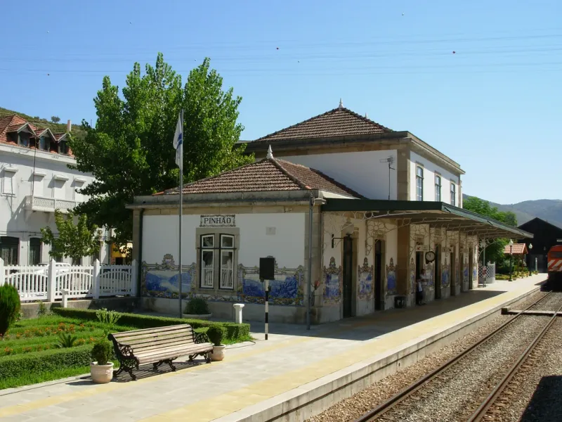 A small railway station with blue azulejo panels along the platform