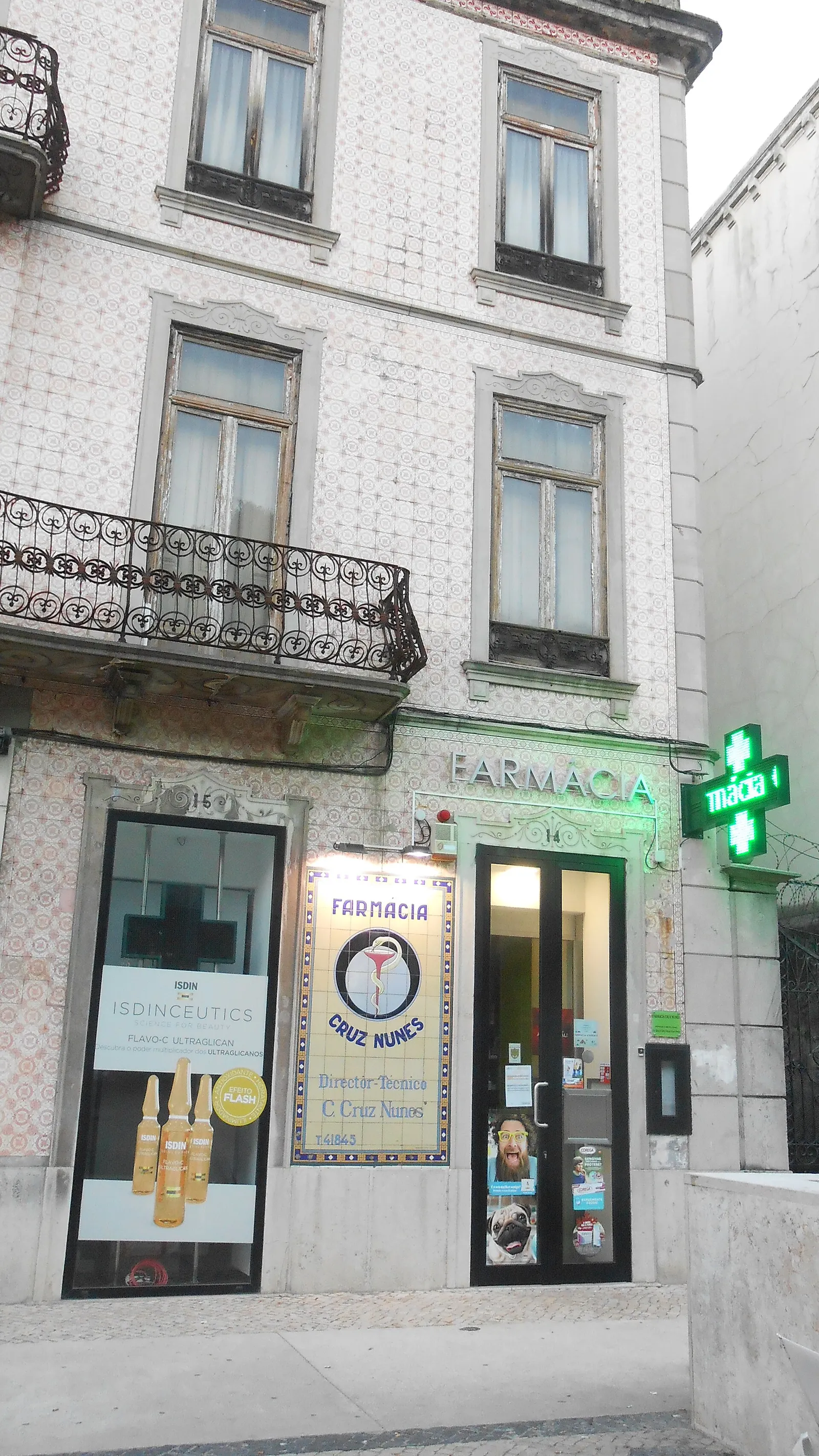 Traditional farmacia storefront with signage on a Lisbon street in Portugal