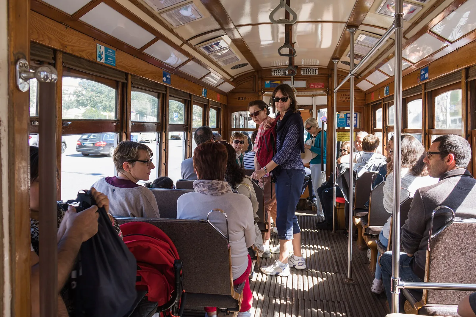 Passengers boarding the famous yellow Tram 28 on a busy Lisbon street