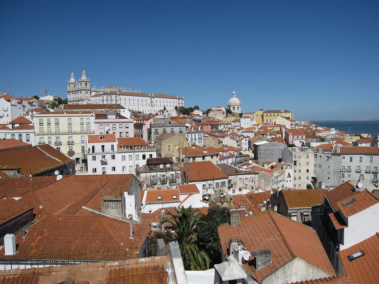 The white towers of the São Vicente de Fora monastery above the rooftops of Alfama in Lisbon, Portugal, on a sunny day