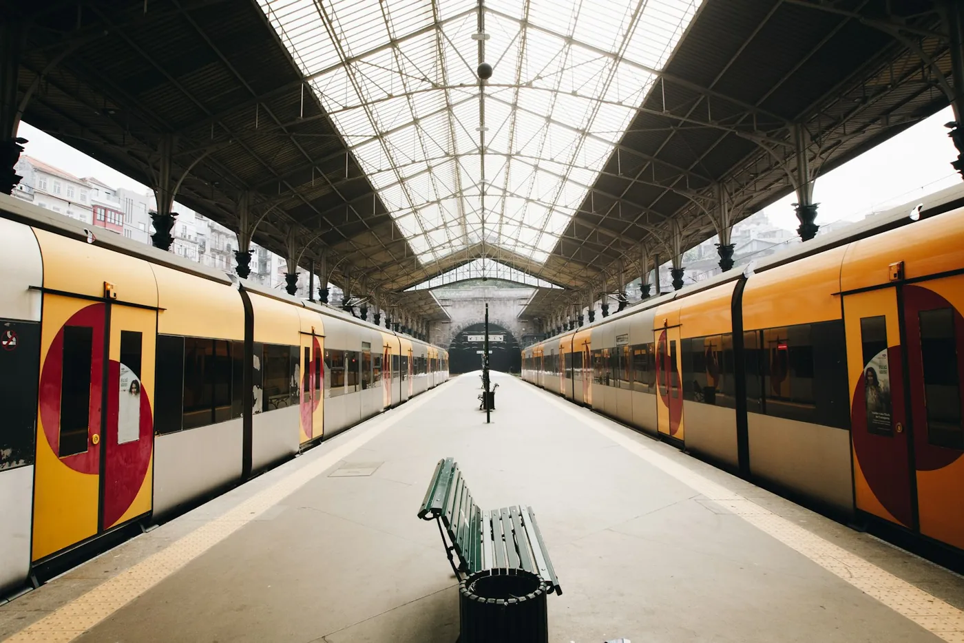 A Comboios de Portugal train waiting under the glass canopy of a station in Porto, Portugal