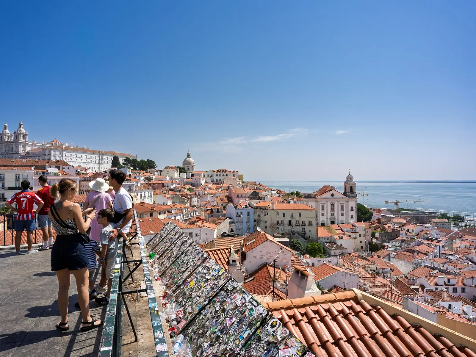 The terracotta rooftops of Alfama and the Tagus river seen from a Lisbon viewpoint