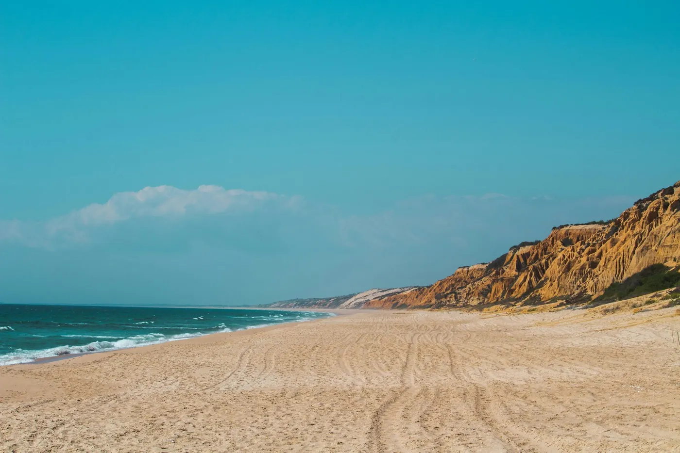 Low dune scrubland and a sandy path near a small fishing village on Portugal's southwest coast